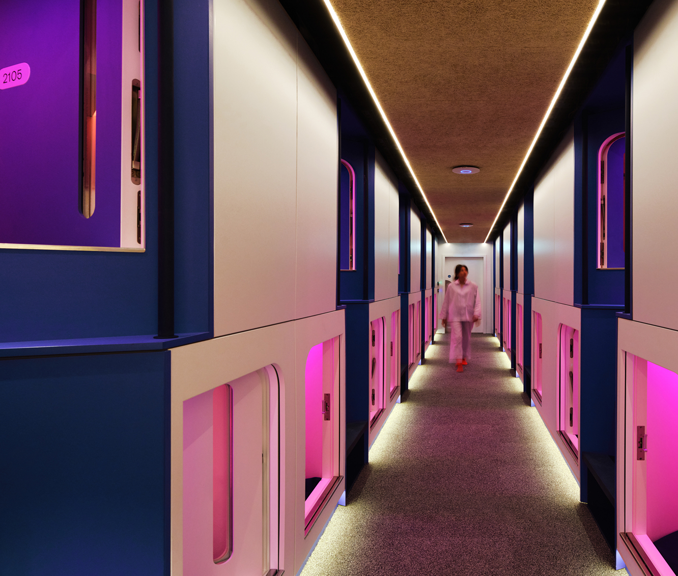 Otherwander Soho Pod Hotel capsule corridor with pink neon lights coming from each capsule
